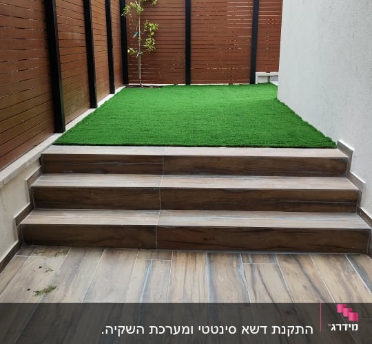 דשא סינתטי ועץ קטן בגינה מגודרת